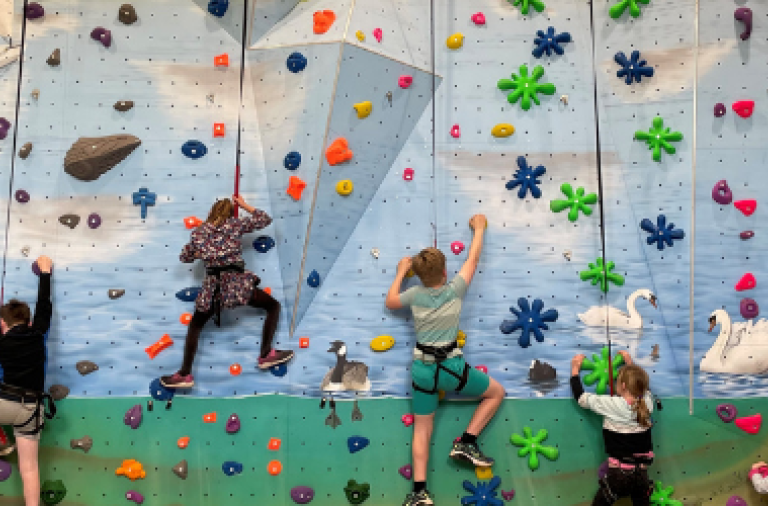 Children climbing the wall at Dinton Activity Centre enjoying the holiday club