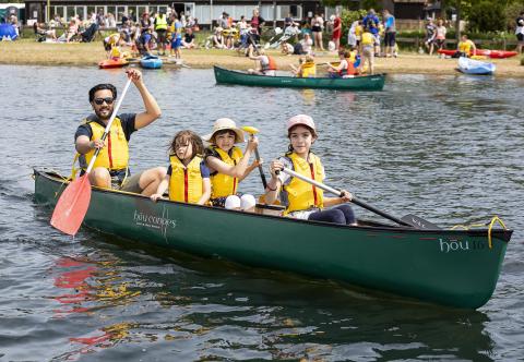 Parent in a canoe with children paddling