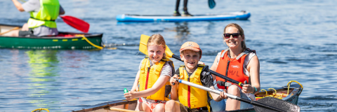 Family enjoying the lake on a double canoe