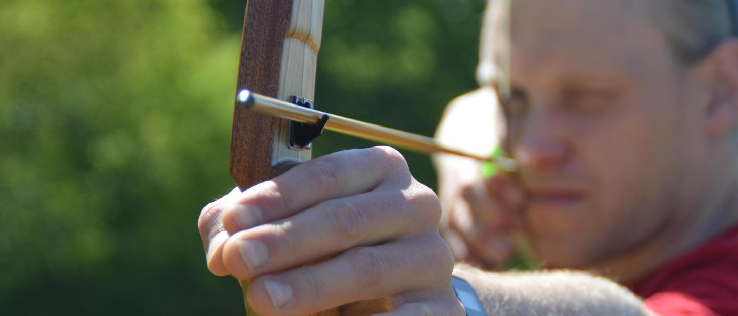 man taking aim with a bow and arrow