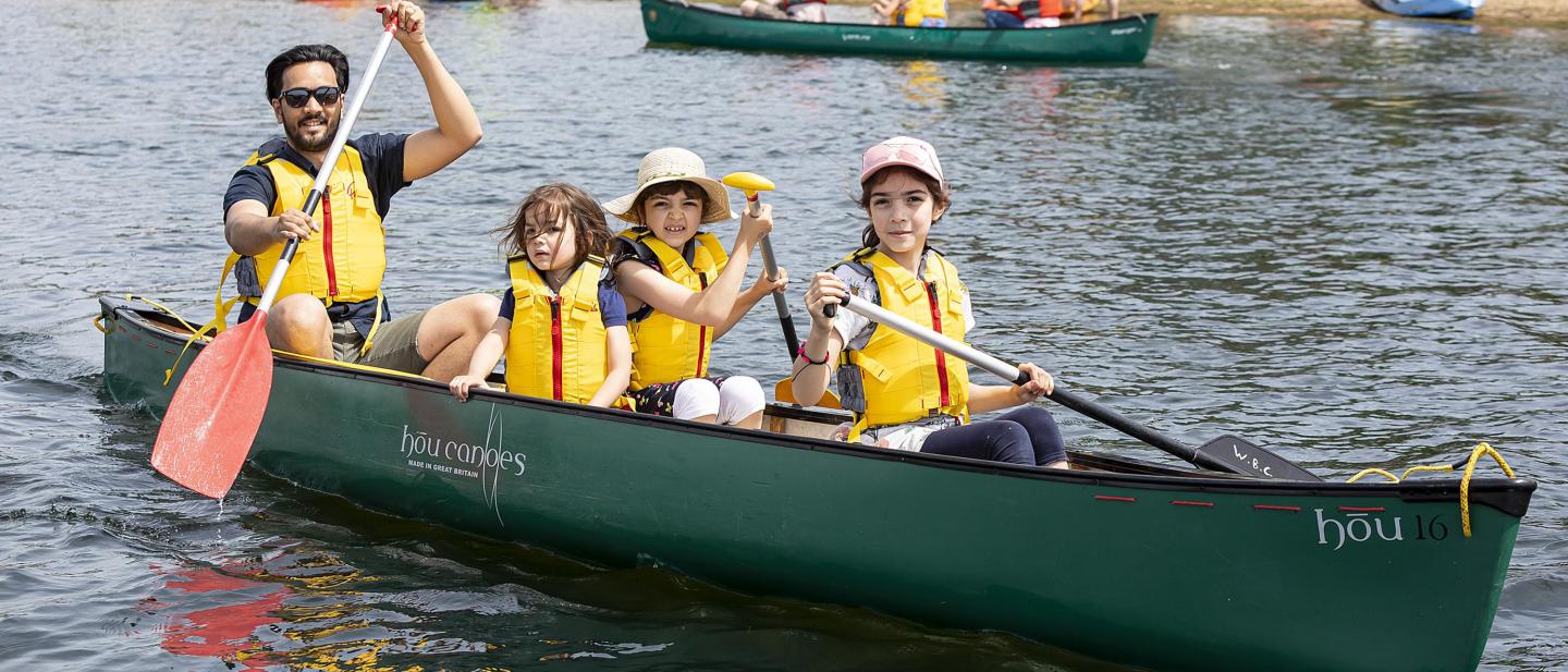 Parent in a canoe with children paddling