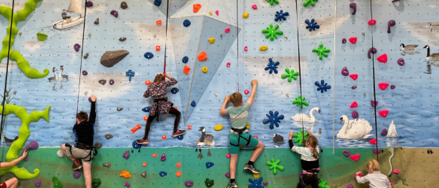 Children climbing the wall at Dinton Activity Centre enjoying the holiday club