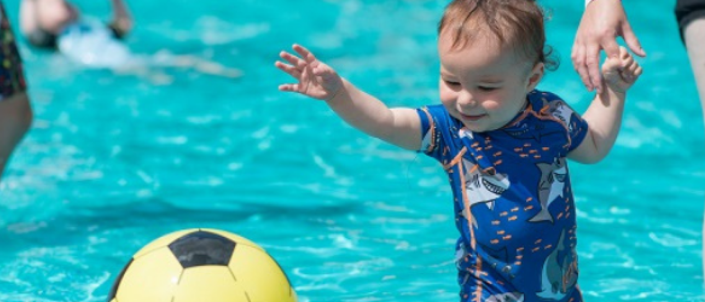 Child and parent playing in the paddling pool