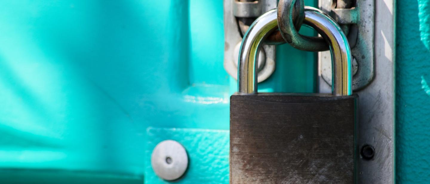 Padlock on large blue doors