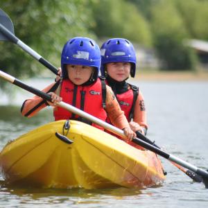 two kids on a double kayak
